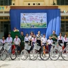 组委会向西宁省新边县新平乡10名贫困学生赠送自行车。图自越通社