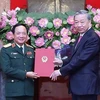 President To Lam (R) hands over the decision to appoint Sen. Lieut. Gen. Trinh Van Quyet as the new Chairman of the General Department of Politics under the Vietnam People's Army. (Photo: VNA)