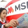 A MSB teller counts money at a transaction office. MSB this year will record an extraordinary income growth from bad debt recovery and capital divestment. (Photo: msb.com.vn)