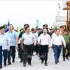 Prime Minister Pham Minh Chinh (second from left) and officials examine the construction site at Highway 61C intersection in Hau Giang Province’s Phung Hiep district on July 13 (Photo: VNA)