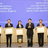 Chairman of the Vietnam-Laos Friendship Association (VLFA) Central Committee Nguyen Dac Vinh (third, right) presents the Friendship Order to 15 members of the Laos-Vietnam Friendship Association (LVFA) Central Committee (Photo: VNA)