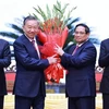 Politburo member and Prime Minister Pham Minh Chinh, on behalf of key and high-ranking leaders of the Party and State, presents flowers to congratulate Party General Secretary To Lam. (Photo: VNA)