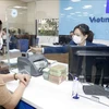 A bank worker with a customer at a VietinBank's office in Hanoi. (Photo: VNA)