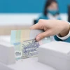 A bank teller counts money at a transaction office in Hanoi. (Photo: vietnamfinance.vn)