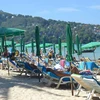 Tourists relax on a beach in Phuket (Photo