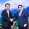 Prime Minister Pham Minh Chinh (R) and visiting Lao Minister of Planning and Investment and Chairman of the Laos-Vietnam Cooperation Committee Phet Phomphiphak at their meeting in Hanoi on August 19. (Photo: VNA).