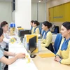 Customers make transactions at a bank in Hanoi. (Photo: chinhphu.vn)