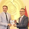 Parliamentary State Secretary of Mecklenburg-West Pomerania Patrick Dahlemann (L) presents a souvenir to Vietnamese Ambassador to Germany Vu Quang Minh (Photo: VNA)