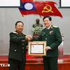 Lao Deputy Prime Minister and Minister of National Defence Gen. Chansamone Chanyalath presents a first-class Labour Order to VMMU Director Nguyen Xuan Kien. (Photo: VNA)