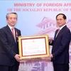 Deputy Prime Minister and Minister of Foreign Affairs Bui Thanh Son (right) presents Friendship Order of the Vietnamese State to Chinese Ambassador Xiong Bo (Photo: VNA)