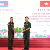 Colonel Pham Dinh Trieu, Political Commissar of the Tay Ninh Border Guard (right), presents a commemorative gift to Lieutenant General Tien Sophonrnvong, Deputy Chief of Staff and Director of the Cambodian order protection department. (Photo: VNA) 