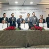 Representatives from The Petrovietnam Technical Services Corporation (PTSC) and its Singaporean partner Sembcorp Utilities Pte Ltd sign agreement at the ceremony. (Photo: VNA)