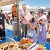 A Japanese family tastes fresh Vietnamese lychees (Photo: VNA)