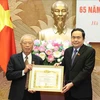 Politburo member, Secretary of the Party Delegation to the National Assembly (NA) and NA Chairman Tran Thanh Man (R) presents the 65-year Party membership badge to Nguyen Van An, former Politburo member and former Chairman of the NA. (Photo: VNA)