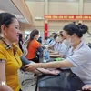 Providing free health check-ups and medicine to workers. (Photo: VNA)