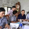 A working delegation from the Ministry of Agriculture and Rural Development led by its Deputy Minister Phung Duc Tien (second from right) inspects the traceability records of aquatic products at Cua Viet fishing port in Quang Tri province. (Photo: VNA)