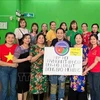 Representatives of the Vietnamese Association in Macau in a group photo with the token of their fund raised for victims of Typhoon Yagi in Vietnam (Photo: VNA)