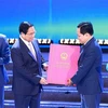 Prime Minister Pham Minh Chinh hands over the decision approving Bac Ninh's master plan for 2021-2023, with a vision to 2050. (Photo: VNA)