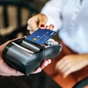 A customer uses a card for payment at a point-of-sale (Photo: VNA).