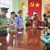 Tran Thi Hong Duyen and Bui Thi Anh Ngoc listen to their arrest warrant at the police station. (Photo: VNA)