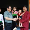 Prime Minister Pham Minh Chinh (2nd from left) visits the family of Xa Van Vong (2nd from right) in Son Phu hamlet, Cao Son commune, Da Bac district, Hoa Binh province, who recently moved into new homes as part of the temporary housing eradication initiative. (Photo: VNA)