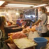 A shopper uses a QR code to make contactless payment to her butcher in Nonthaburi. (Photo: Bangkokpost)