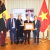 Vietnamese Ambassador to Belgium Nguyen Van Thao (R) presents the Friendship Order of the Vietnamese State in recognition of Jean Salmon's great contributions to the Vietnam-Belgium cooperation to his family. (Photo: VNA)