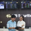 A trader talks to an investor on a trading floor of a securities firm (Photo: VNA)