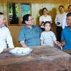 Prime Minister Pham Minh Chinh (second, left) visits a family benefited from the movement to build and repair houses for the needy in Hien Luong commune in Da Bac district of Hoa Binh province. (Photo: VNA)