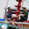 A fishing ship owner and an officer of the Phu Yen provincial Border Guard Command inspect the vessel monitoring system (VMS) on a fishing boat. (Photo: VNA)