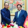 Prime Minister Pham Minh Chinh (R) and his Malaysian counterpart Anwar Ibrahim at their meeting in Vientiane on October 10. (Photo: VNA)