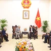 Deputy Prime Minister Tran Hong Ha (centre, right) receives Professors Tran Thanh Van and scientists and researchers from the International Centre for Interdisciplinary Science and Education (ICISE) in Hanoi on October 11. (Photo: VNA)