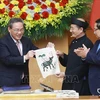 Vietnamese Prime Minister Pham Minh Chinh (R) and Chinese Premier Li Qiang got hands-on experience of making a Dong Ho folk painting. (Photo: VNA)