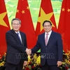 Prime Minister Pham Minh Chinh (R) shakes hands with Chinese Premier Li Qiang. (Photo: VNA)