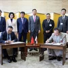 Chairman of the Hanoi People's Committee Tran Sy Thanh and Governor of Kanagawa Prefecture Kuroiwa Yuji sign the Memorandum of Understanding between the two localities. (Photo: VNA)