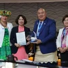 Deputy Minister of Health of Assoc. Prof. Nguyen Thi Lien Huong (2nd from left) receives a certificate and a plaque honouring Vietnam's elimination of trachoma. (Photo: nhandan.vn)