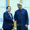 Prime Minister Pham Minh Chinh (L) shakes hands with President of the United Arab Emirates (UAE) Sheikh Mohammed bin Zayed Al Nahyan (Photo: VNA)