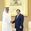 Prime Minister Pham Minh Chinh (R) shakes hands with Sheikh Hamad Bin Zayed Al Nahyan, Director of the Abu Dhabi Investment Authority (ADIA) of the UAE. (Photo: VNA)