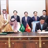 PM Pham Minh Chinh (behind, centre) and officials witness the signing of an MoU on economic and trade cooperation between the Vietnamese Ministry of Industry and Trade and the Saudi Arabian Ministry of Economy and Planning on October 30. (Photo: VNA)