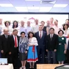 Participants pose for a group photo at the get-together in HCM City on November 5. (Photo: VNA)