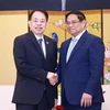 Prime Minister Pham Minh Chinh (R) receives ADB President Masatsugu Asakawa (Photo: VNA)