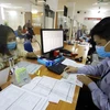 A worker fills out paperwork to claim unemployment benefits at the Hanoi Employment Service Centre. (Photo: VNA) 