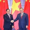 Prime Minister Pham Minh Chinh (L) shakes hands with Chinese Premier Li Qiang. (Photo: VNA)