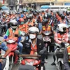 Motorcycle taxis parade in front of Bangkok City Hall in March last year to encourage riders to wear helmets. (Photo: bangkokpost)