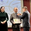 UEVF President Nguyen Phan Bao Thuy presents insignias to Vietnamese Ambassador to France Dinh Toan Thang and Ambassador Nguyen Thi Van Anh (Photo: VNA)