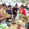 People visit the Vietnamese booth at the festival and try Vietnamese specialties. (Photo: VNA)