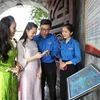 Youth Union members guide tourists to scan QR codes to learn about the Xuong Giang Victory historical site. (Photo: VNA)