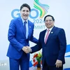 PM Pham Minh Chinh (R) shakes hands with his Canadian counterpart Justin Trudeau (Photo: VNA)