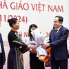 National Assembly Chairman Tran Thanh Man presents flowers to lawmakers who are teachers, and former teachers and education managers in Hanoi on November 20. (Photo: VNA)