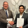 VNEI Chairman Nguyen Trung Dung (R) and CICAN Vice President Alain Roy pose for a photo after signing the cooperation agreement. (Photo: VNA)